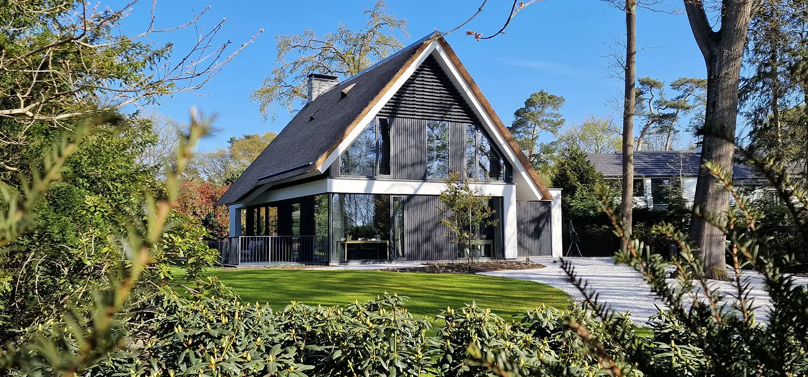 Samenspel van hout, stucwerk en glas in de gevelcompositie van de villa