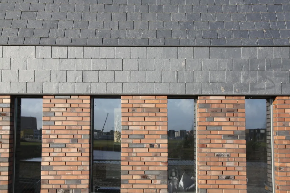 Pleinzijde van de woning met atelierentree en groene buitenruimte