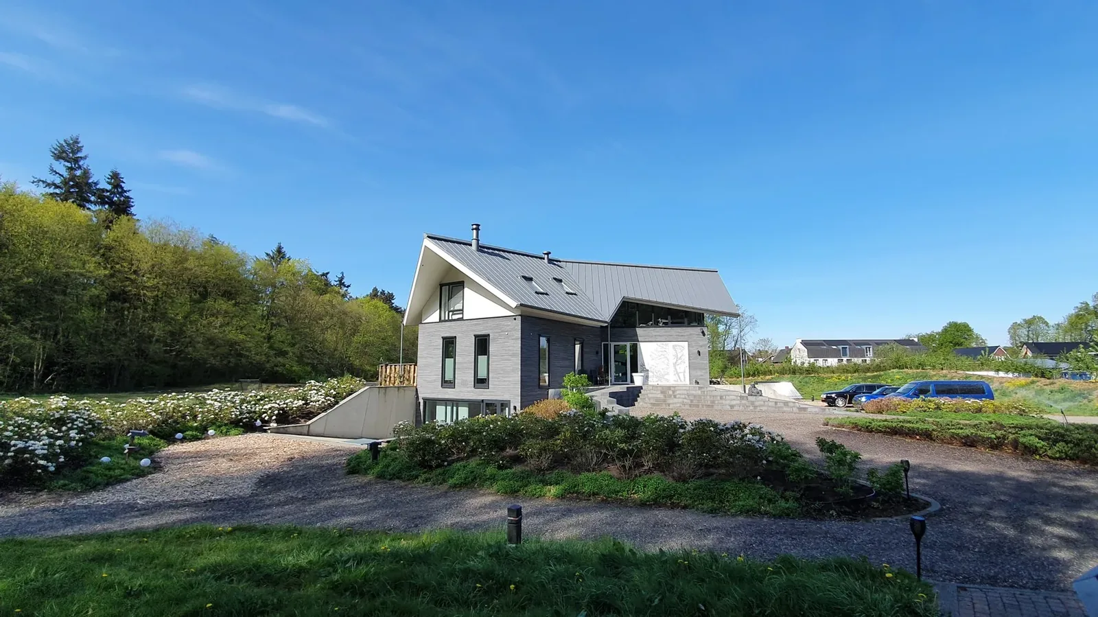 Slingerende oprijlaan die de villa geleidelijk ontsluit vanaf de rondweg