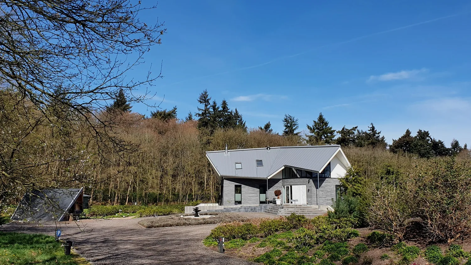 Villa met drie vleugels die privacy en zichtlijnen op de bosrand combineert