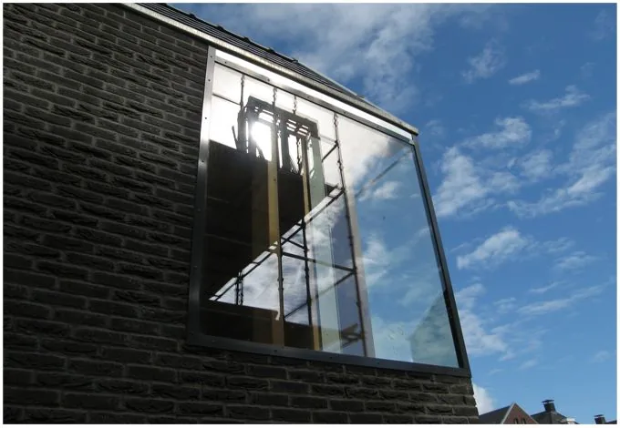 Tuinmuur koppelt woning en garage/studio tot één samenhangend ensemble