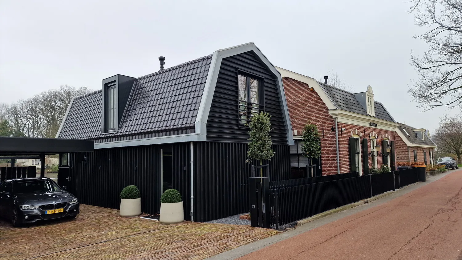 Houten geveldelen met eigentijdse belijning als referentie aan schuren in de omgeving.