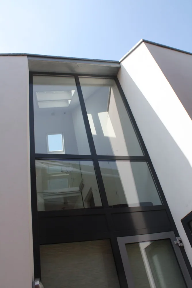 Gevelbeeld met vlak liggende aluminium kozijnen in gekeimde gevel