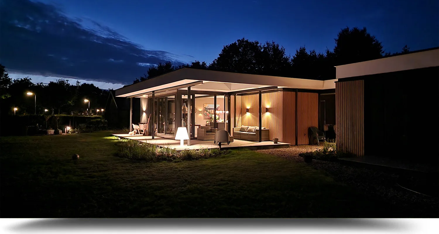 Avondbeeld van villa Ruurlo met sfeervolle verlichting en warme materialisatie