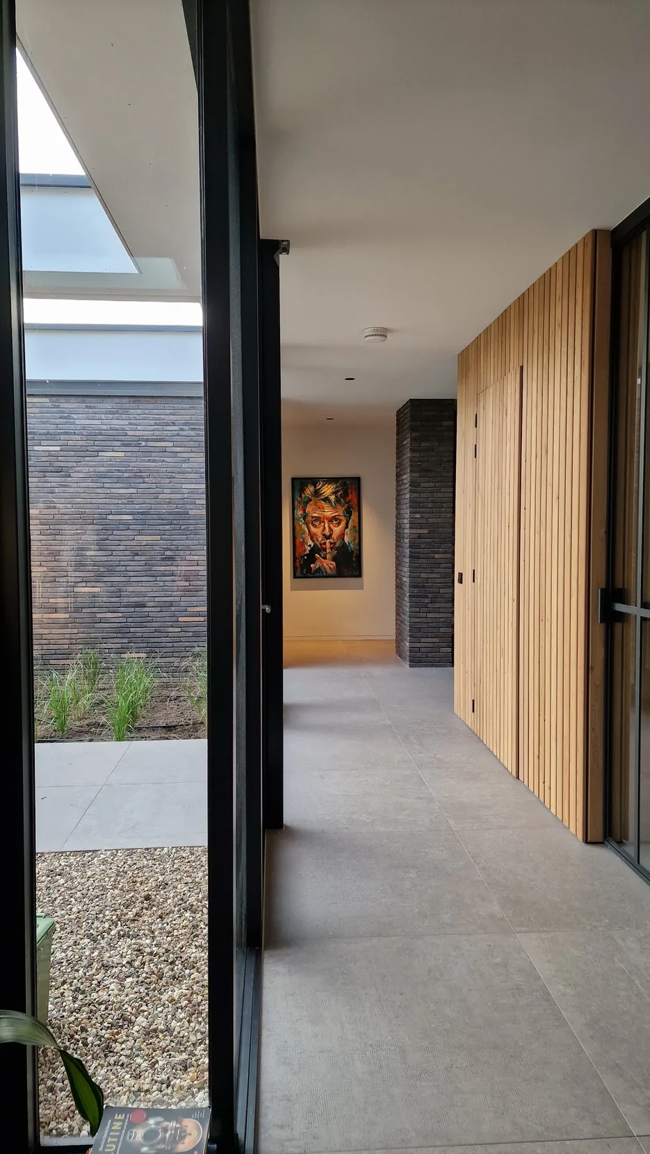 Zichtlijnen door de woning tussen wonen, patios en tuin met doorlopende materialisatie