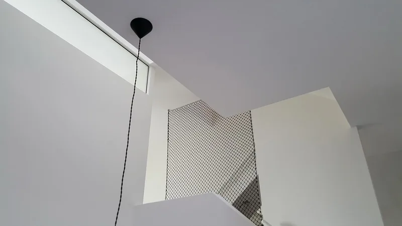 Woonruimte met vide en hoge kastwand als ruimtelijk middelpunt in de stadswoning