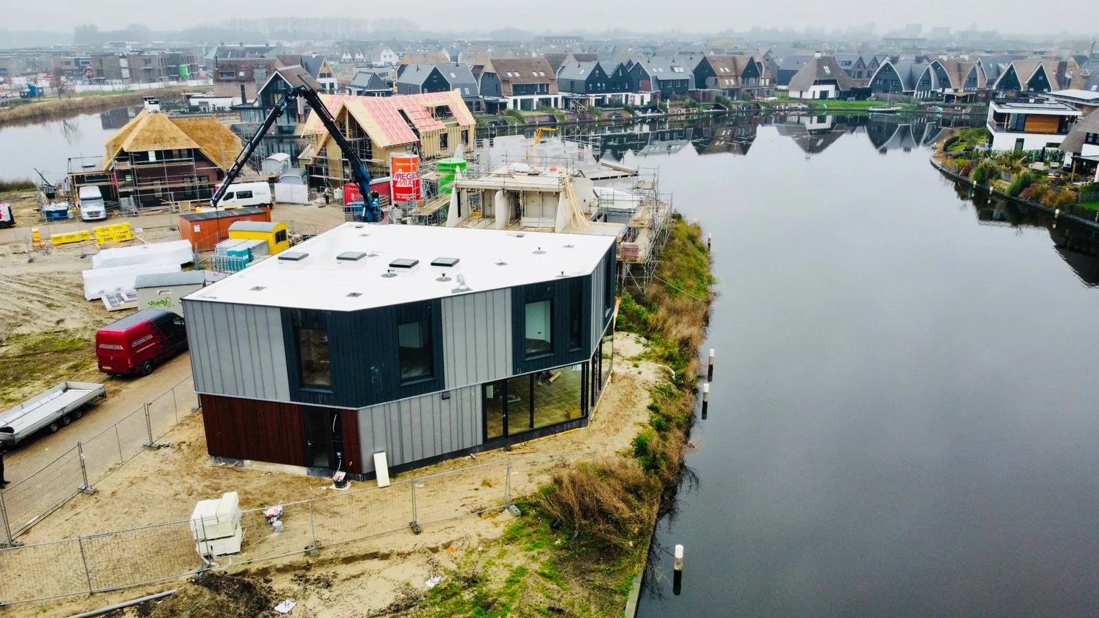 Woonruimtes met zichtlijnen over het water en grote schuifpuien.