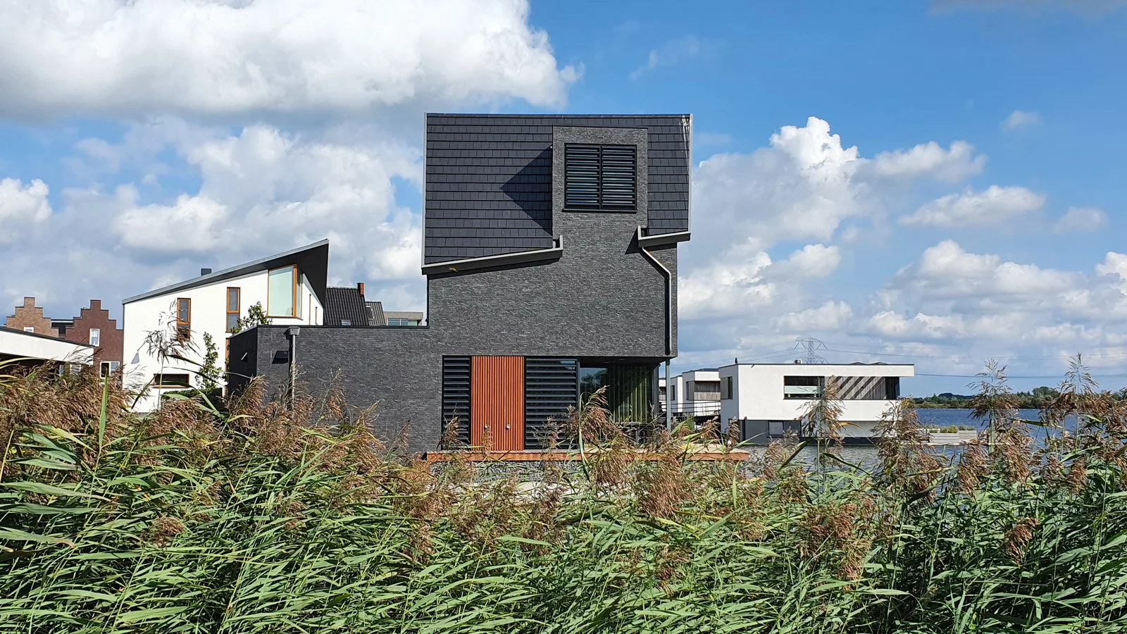 Gevelmaterialen en daklijn van de villa aan het water in Waterrijk Woerden.
