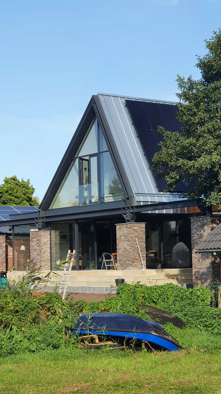 Entree via cortenstalen hellingbaan naar verhoogde woning.