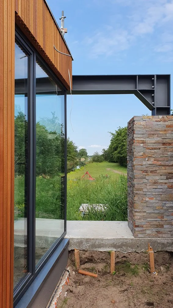 Overdekt terras aan de eetkamer als overgang tussen binnen en buiten.